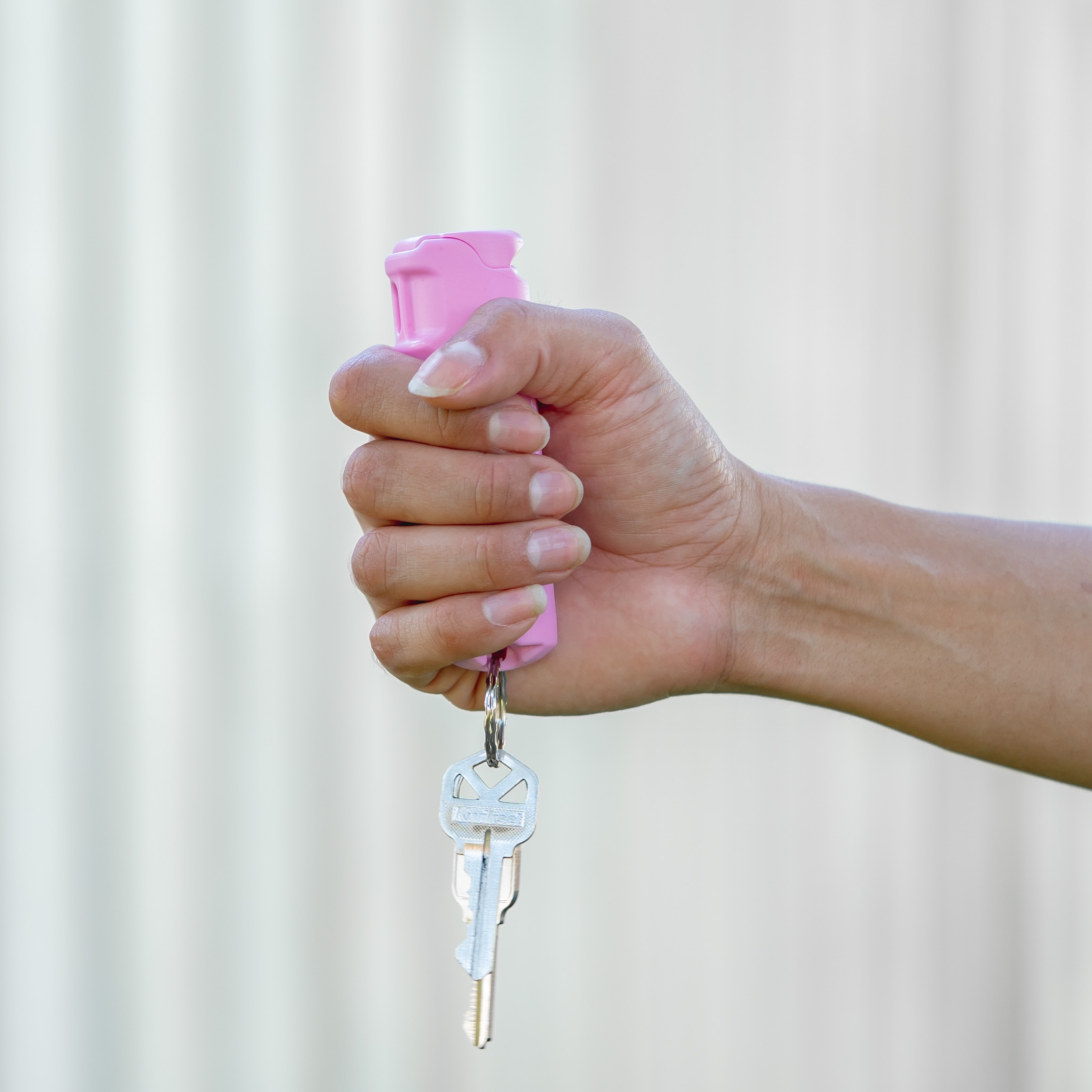 Police Magnum pink pepper spray keychain for women pink pepper spray keychain for women held in hand